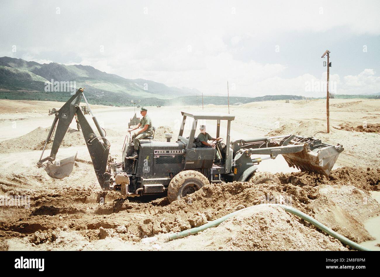 Ein Seabee betreibt den Heckbagger eines Laders als Mitglieder einer Luftschaffeneinheit des Naval Mobile Construction Battalion 133 (NMCB-133), um die Landebahn auf einem irakischen Flugplatz zu reparieren. Die Seabees reparieren den Flugplatz, der vor Beginn des Golfkriegs im Bau war, um Hilfslieferungen für die kurdischen Flüchtlinge in der Nähe im Rahmen der Operation Provide Comfort zu ermöglichen. Betreff Betrieb/Serie: KOMFORTBASIS: Sirsenk Land: Irak (IRQ) Stockfoto