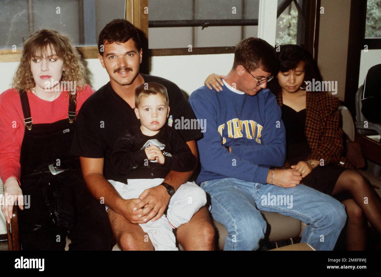 Zwei Marineservisten sitzen bei ihren Familien und warten, bis ihre Bearbeitung durch das Marineserviceeinsatzkommando 20 (REDCOM-20) abgeschlossen ist. Die Reservisten sind gerade aus dem Dienst im Persischen Golf nach der Operation Desert Storm zurückgekehrt. Betreff Operation/Serie: WÜSTENSTURMBASIS: San Francisco Bundesstaat: Kalifornien (CA) Land: Vereinigte Staaten von Amerika (USA) Stockfoto