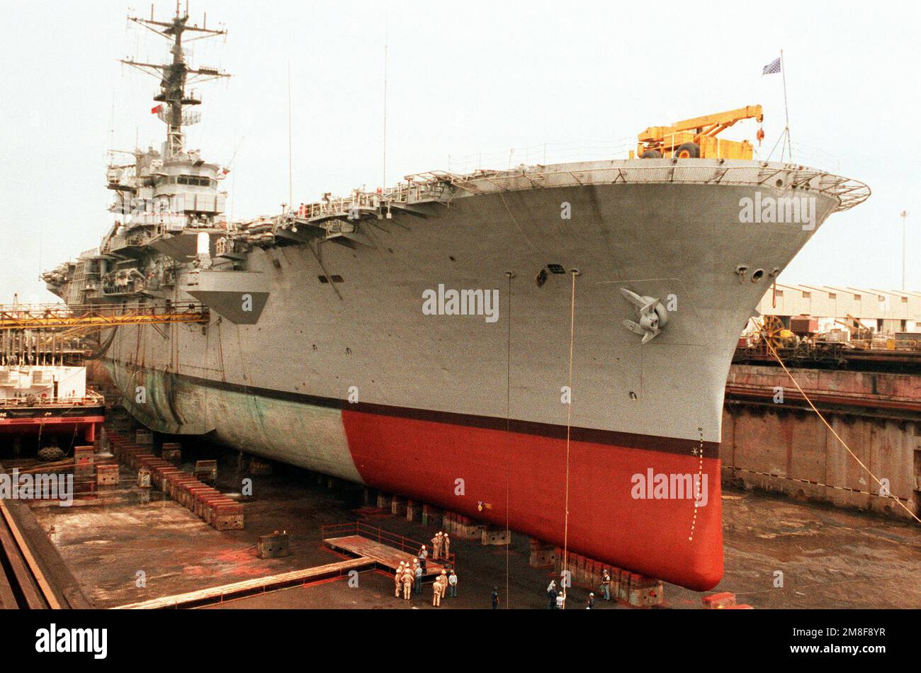 Das amphibische Sturmschiff USS TRIPOLI (LPH-10) befindet sich im Trockendock nach Reparatur eines großen Lochs 10 Fuß unter seiner Wasserlinie. Vier Seeleute wurden verletzt und das Schiff wurde schwer beschädigt, als am 18. Februar in der Nähe der TRIPOLIS eine irakische Mine explodierte, als Hubschrauber des Schiffes während der Operation Desert Storm Minenräumungen im Persischen Golf durchführten. Betreff Operation/Serie: WÜSTENSTURM Land: Bahrain (BHR) Stockfoto