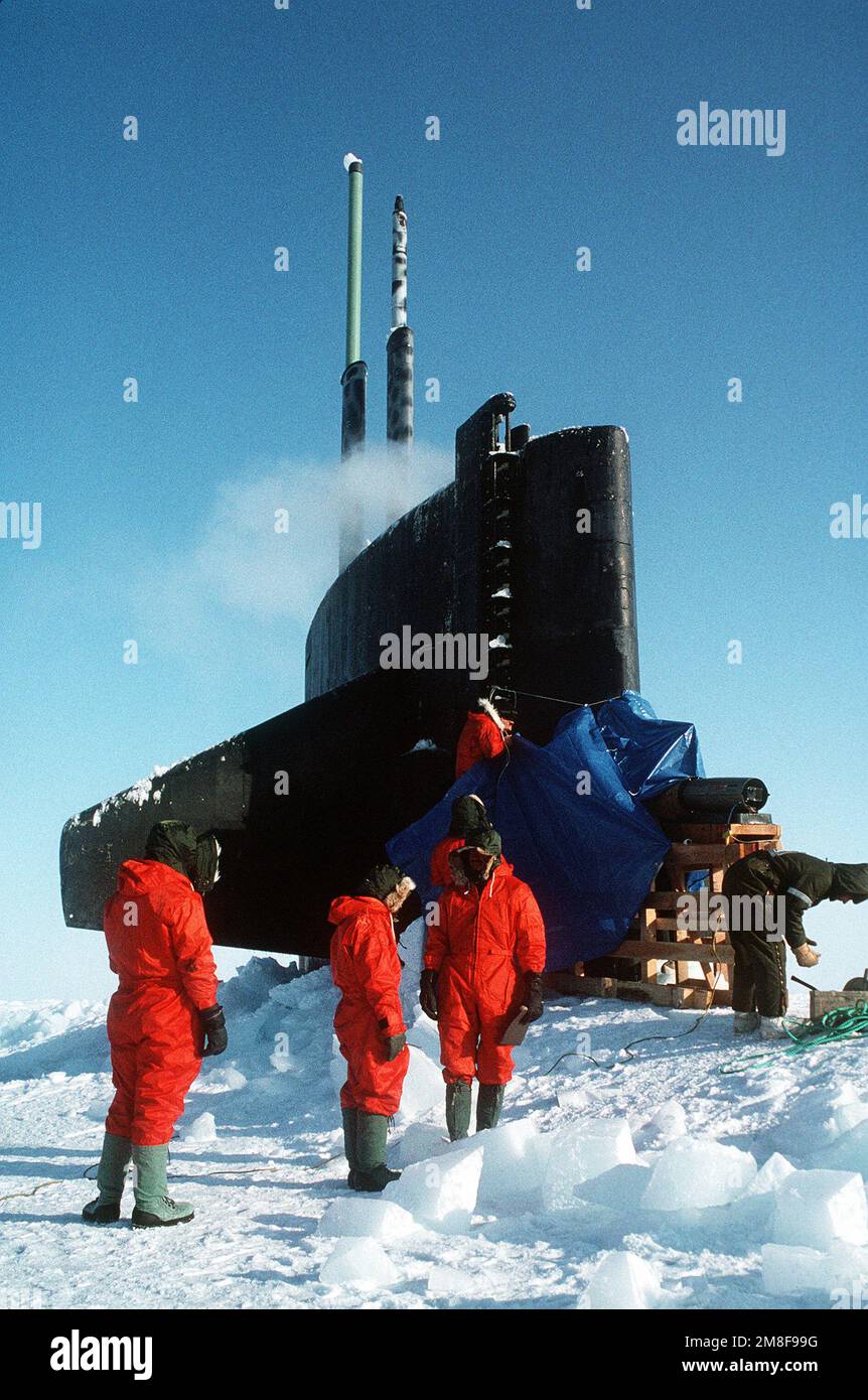 Besatzungsmitglieder versammeln sich in der Nähe des Segels des