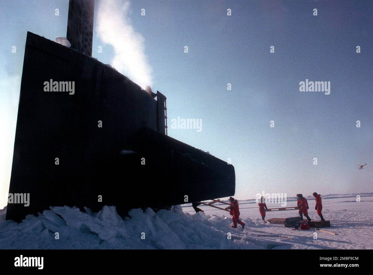 Crewmen des nuklearbetriebenen Angriffs-U-Boots USS PARGO (SSN-650) bringen leere Paletten zurück an Bord des U-Boots, nachdem sie Vorräte in einem Eislager nördlich des Polarkreises abgegeben haben. Land: Unbekannt Stockfoto