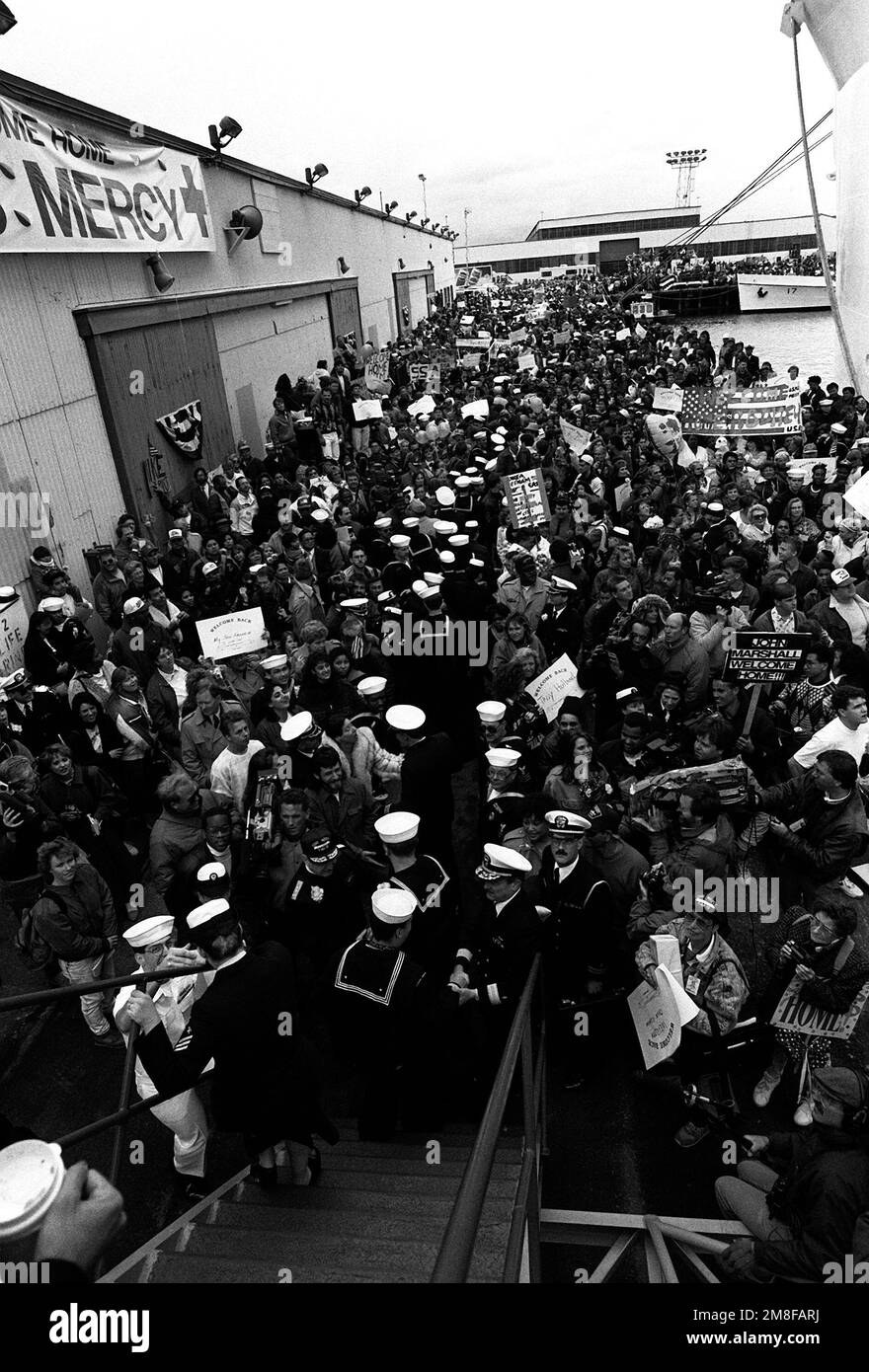 Medizinisches Personal des Krankenhausschiffs USNS MERCY (T-AH-19) trifft sich nach dem Verlassen des Schiffs mit Angehörigen der Menge auf dem Pier wieder. Die GNADE ist nach San Francisco zurückgekehrt, nachdem sie während der Operation Desert Storm im Persischen Golf stationiert wurde. Betreff Operation/Serie: WÜSTENSTURMBASIS: San Francisco Bundesstaat: Kalifornien (CA) Land: Vereinigte Staaten von Amerika (USA) Stockfoto