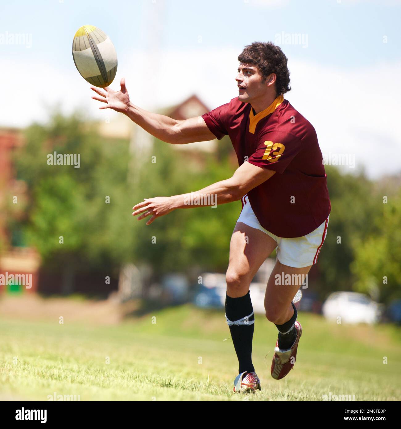 Meine Leidenschaft. Die volle Länge eines jungen Rugbyspielers, der einen Pass erhält. Stockfoto