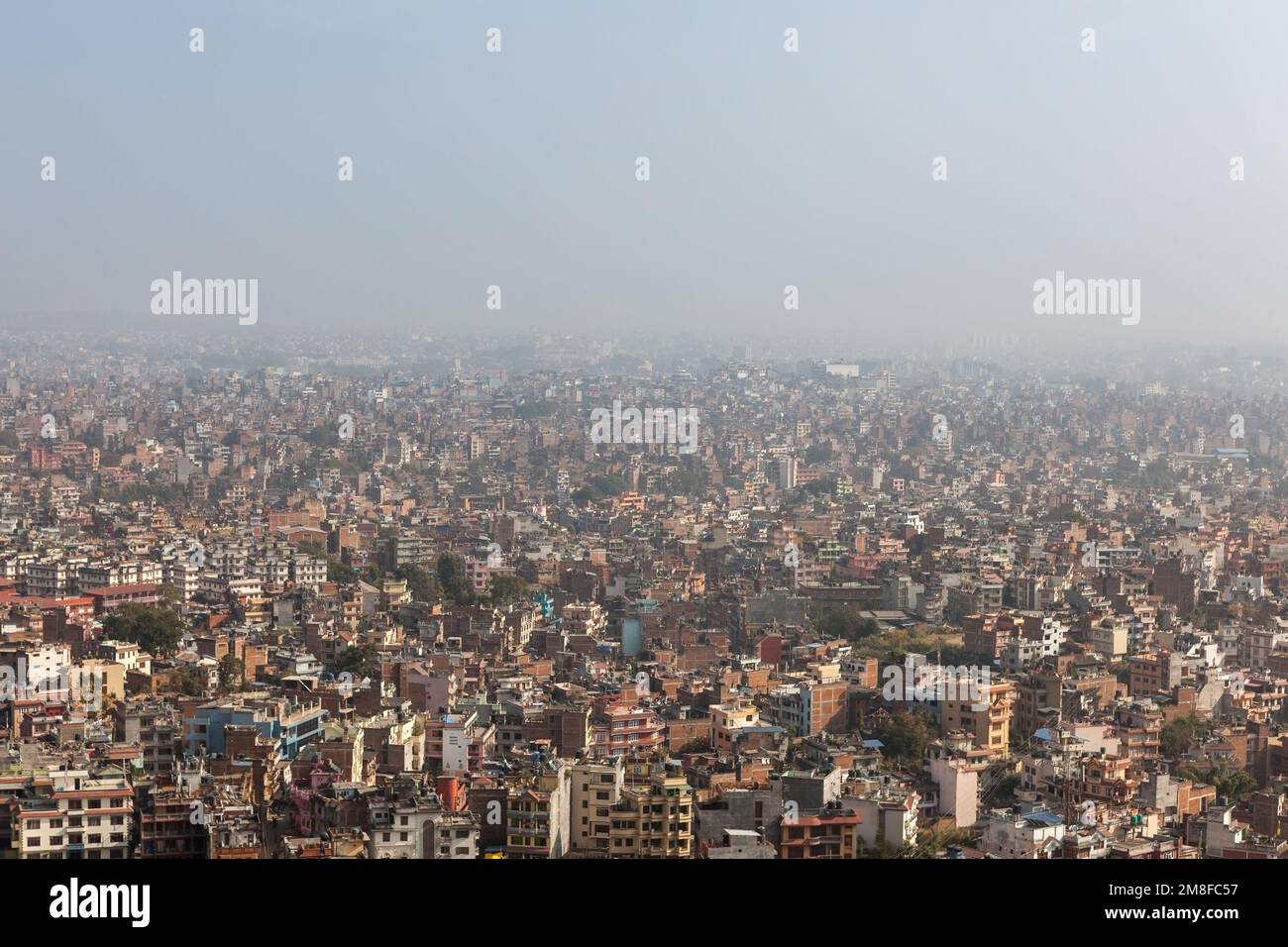 Luftaufnahme über die nepalesische Hauptstadt Kathmandu vom Swayambhunath-Tempel. Große, riesige asiatische Stadt bedeckt mit dichtem Smog, ohne sichtbare Grenzen und Str. Stockfoto