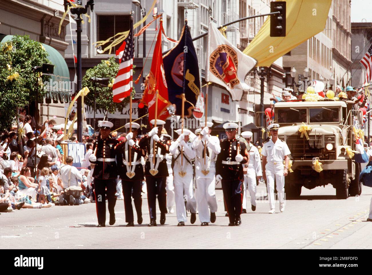 Während der „San Diego salutes the troops“-Parade marschiert ein Navy-Marine-Corps-Farbwächter des San Diego Naval and Marine Corps Reserve Readiness Center vor einem M-939 5-Tonnen-Truck. Die Parade findet zu Ehren aller Veteranen statt, mit besonderer Anerkennung für Einheiten, die an Operation Desert Shield und Operation Desert Storm beteiligt waren. Betreff Operation/Serie: DESERT SHIELD DESERT STORM Base: San Diego Staat: Kalifornien (CA) Land: Vereinigte Staaten von Amerika (USA) Stockfoto