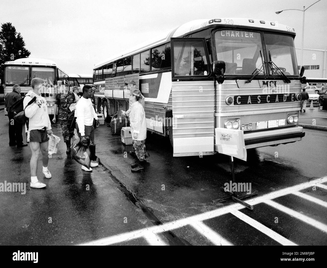 Gecharterte Busse stehen bereit, um Zivilisten und Militärpersonal zu einem nahe gelegenen Flughafen zu transportieren, wo sie nach ihrer Evakuierung aus den Philippinen die letzte Etappe ihrer Reise antreten. Die Evakuierten wurden nach dem Ausbruch des Mount Pinatubo, eines Vulkans, der am 10. Juni zum ersten Mal seit über 600 Jahren zum Leben erweckt wurde, von der Marinestützstelle Subic Bay und dem Luftwaffenstützpunkt Clark transportiert. Mehr als 20.000 Evakuierte wurden im Rahmen der US-Militäroperation Fiery Vigil aus dem Gebiet entfernt. Einsatzgebiet: FIERY WIGIL Base: McChord Air Force Base State: Washington(WA) Country: United States O Stockfoto