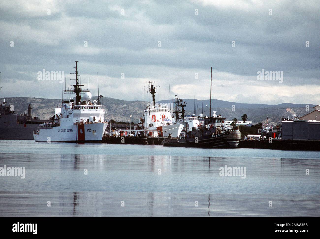 Der Cutter USCGC THETIS (WMEC-910) mit mittlerer Ausdauer, der Cutter USCGC COURAGEOUS (WMCE-622) mit mittlerer Ausdauer und der große Hafenschlepper WARMASSA (YTB-820) stehen im Hafen. Die Schneidemaschinen werden verwendet, um haitianische Flüchtlinge zu transportieren, die vor politischen und wirtschaftlichen Umwälzungen in ihrer Heimat fliehen. Basis: Guantanamo Bay Country: Kuba (CUB) Stockfoto