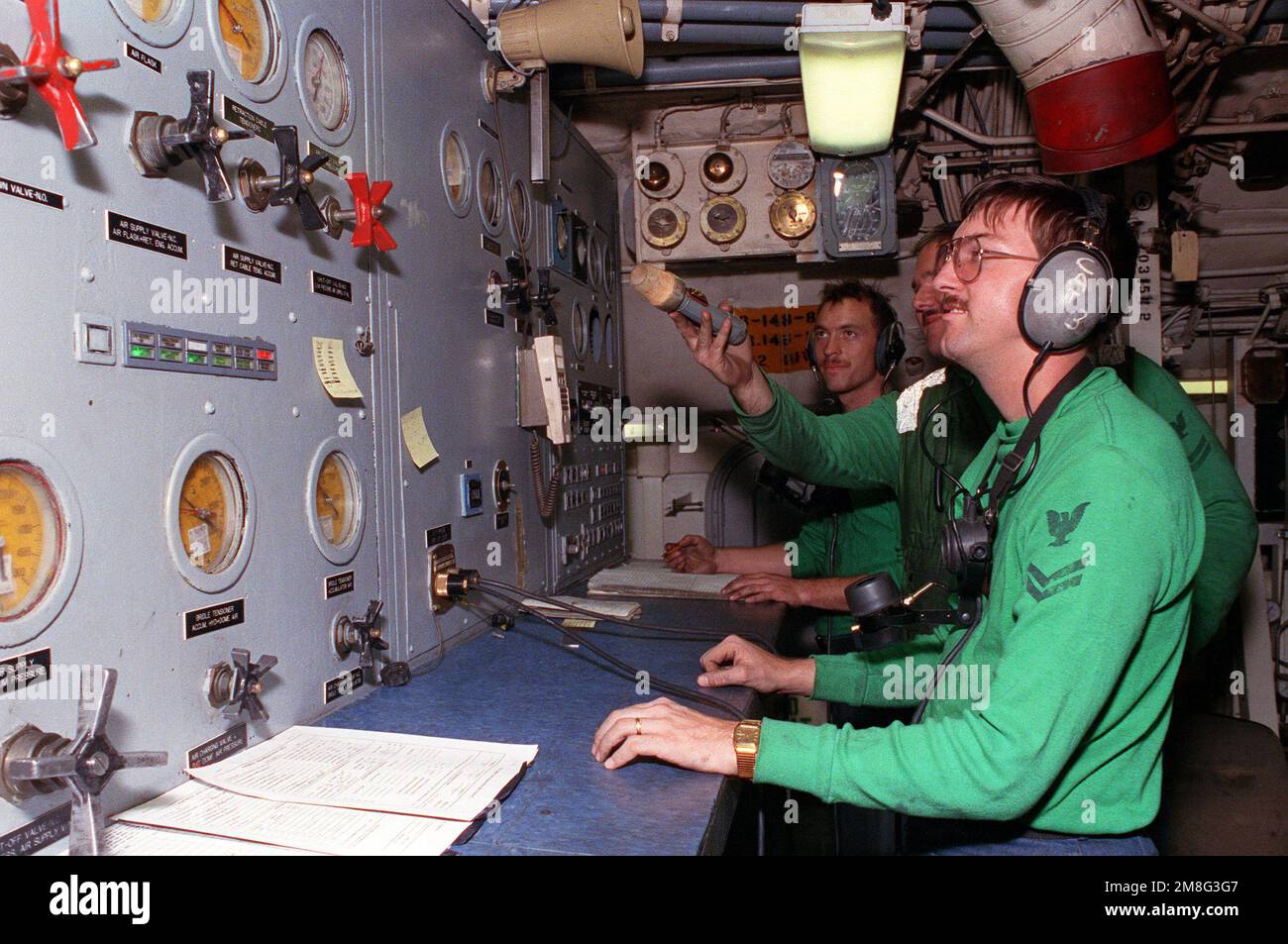 Besatzungsmitglieder an Bord des nuklearbetriebenen Flugzeugträgers USS DWIGHT D. EISENHOWER (CVN-69) überwachen den Druck auf das Katapultsystem, während der Träger während der Seeverbotsmaßnahmen unterwegs ist. Zu den Besatzungsmitgliedern gehören: Aviation Boatswain's Mate (Ausrüstung) 2. Class James Simmons, Aviation Boatswain's Mate (Ausrüstung) 2. Class Wesley Knudsen und AIRMAN Apprentice Brian Young. Basis: USS Dwight D Eisenhower (CVN 69) Stockfoto