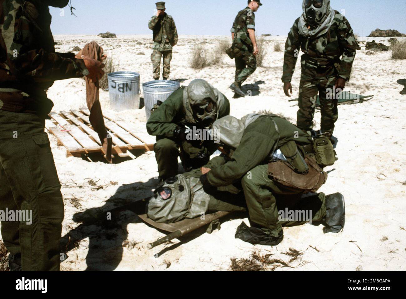 Mitglieder von Kompanie C, 1. Milliarden Dollar, 10. Marines, tragen Gasmasken und Schutzkleidung, nehmen an einer Massenentseuchungsübung an einem Strand im Persischen Golf während der Operation Desert Shield Teil. Betroffene Operation/Serie: WÜSTENSCHILD Land: Unbekannt Stockfoto