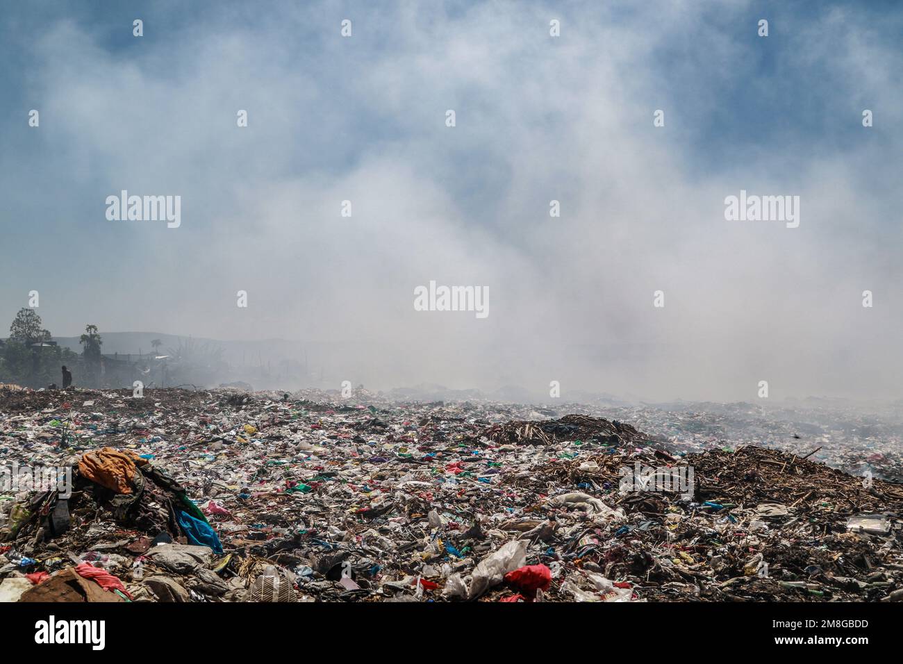Müllsammler sammeln Abfälle, um sie in starkem Rauch zu recyceln, indem sie Müll auf dem Hauptlagerplatz von Nakuru verbrennen. Da Abfälle selten getrennt und stark mit allen Arten von Abfall vermischt werden, kann das Verbrennen potenziell giftige Dämpfe erzeugen, die ein Problem für die öffentliche Gesundheit darstellen und auch zum Klimawandel beitragen können. Gemeinden, die in der Nähe von Mülldeponien arbeiten und leben, wo Müll offen verbrannt wird, sind dem Risiko von Atemwegserkrankungen und Krebs ausgesetzt. Frauen, die diesen Dämpfen ausgesetzt sind, können unter reproduktiven Gesundheitsproblemen leiden. (Foto: James Wakibia/SOPA Images/Sipa USA) Stockfoto