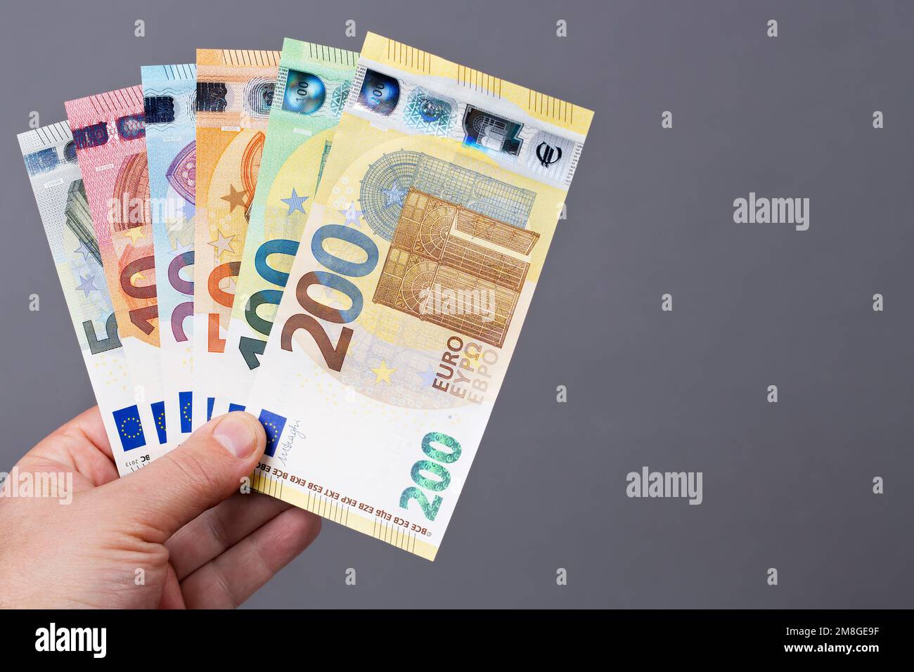 Europäisches Geld - eine neue Banknotenserie in der Hand auf grauem Hintergrund Stockfoto