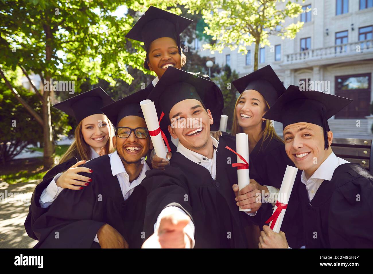 Ex-Student macht Selfie mit seinen Klassenkameraden nach der Graphikzeremonie. Stockfoto