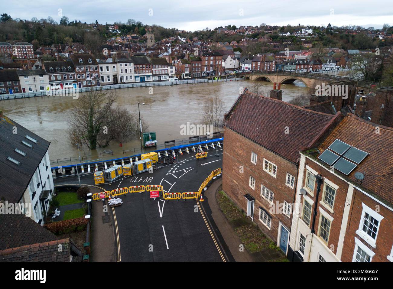 Bewdley, Worcestershire, Großbritannien. 14. Januar 2023 - die Mitarbeiter der Umweltbehörde hielten den Atem an, als der Fluss Severn vor den Hochwasserschutzbarrieren in Beales Corner weiter steigt, die derzeit die tosenden Wasserströme zurückhalten, die derzeit 4,6 m hoch sind und die zu Beginn erwarteten Spitzenwerte erreichen Öffnungszeiten des Sonntagvormittags. Für den Westen Englands wurde eine gelbe Wetterwarnung für Starkregen angekündigt, die sich weiter auf den Anstieg des Flusses auswirkt. Quelle: Stop Press Media/Alamy Live News Stockfoto
