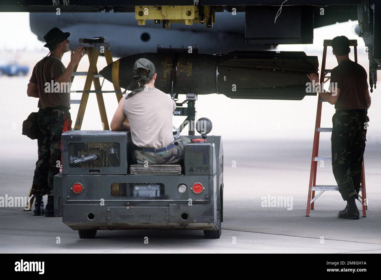 Mitglieder des Munitions Maintenance Squadron von 1708. verwenden einen MJ-1 Bombenlader, um M-117 750-Pfund Bomben auf ein B-52G Stratofortress Bomberflugzeug während der Operation Desert Storm zu laden. Betreff Operation/Serie: WÜSTENSTURM Land: Saudi-Arabien (Sau) Stockfoto