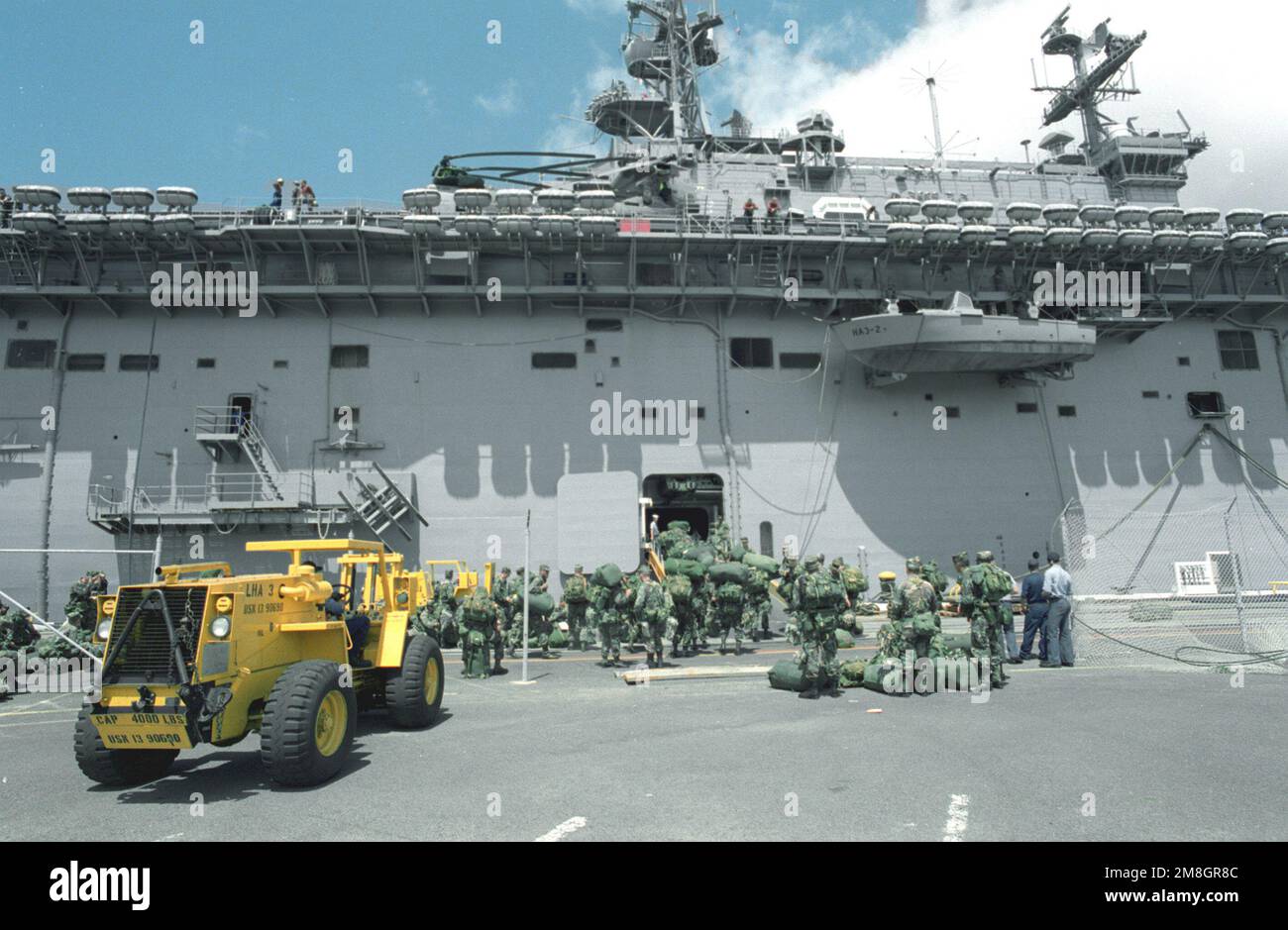 Ein M4K Gabelstapler, einer von vielen Ausrüstungsgegenständen der 25. Infanterie-Division, der für den Transport vorbereitet wird, steht auf dem Pier, während Truppen an Bord des Amphibienschiffs USS BELLEAU WOOD (LHA-3) gehen. Truppen und Ausrüstung werden im Rahmen der Task Force Garden Isle nach Kauai transportiert, einer gemeinsamen militärischen Katastrophenhilfe, die nach dem Hurrikan Iniki durchgeführt wird. Betrifft Operation/Serie: GARDEN ISLE Base: Pearl Harbor Bundesstaat: Hawaii (HI) Land: Vereinigte Staaten von Amerika (USA) Stockfoto