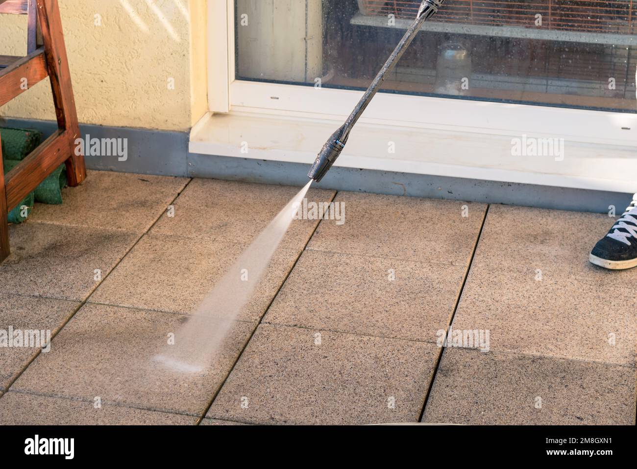 Mann mit Rohrreinigungsterrasse mit Wasserdruck von Schmutz Stockfoto