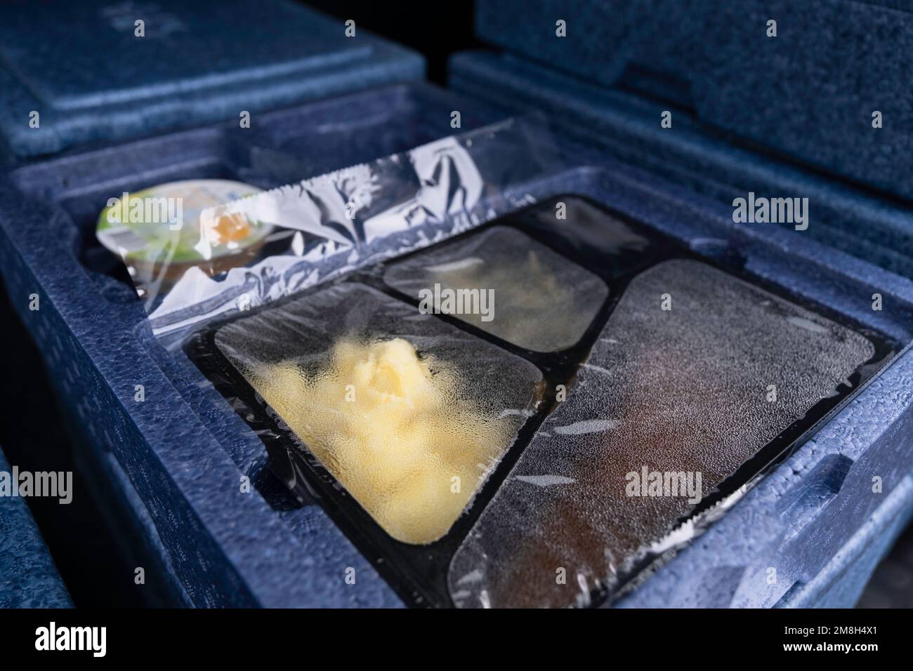 Warme Mahlzeit verpackt in Plastik- und Polystyrolboxen, die an Senioren und Behinderte geliefert werden. Mahlzeiten auf Rädern Stockfoto