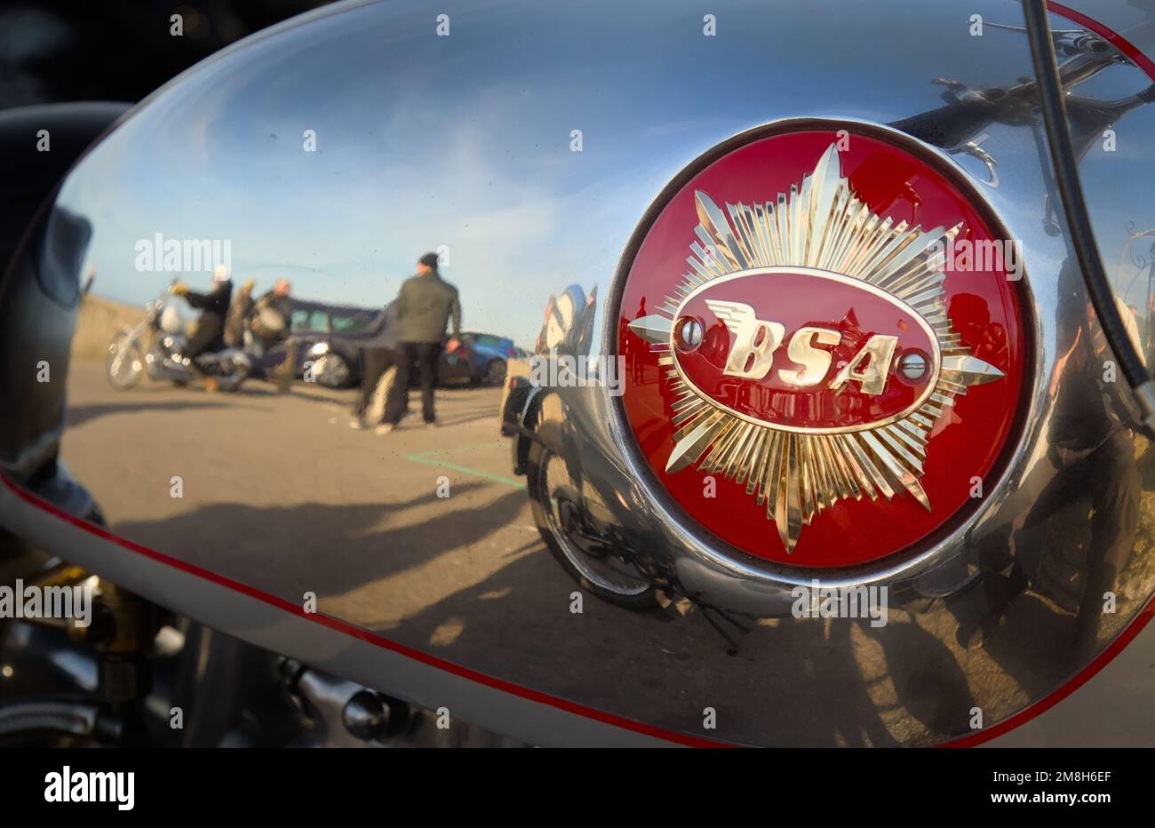Chrom-Benzintank eines BSA Motorrads mit goldenem Sternzeichen und einer Reflexion von Menschen und Mudeford Quay, Großbritannien Stockfoto