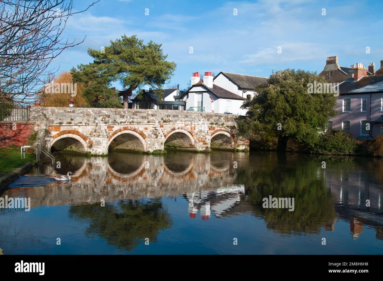 Bridge Street und Bogenbrücke über den Fluss Avon mit Reflektionen im Still River, Christchurch UK Stockfoto