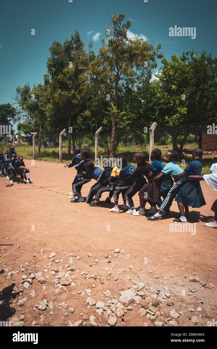 25. März 2022 - Mwanza, Tansania - Kinder, die auf dem Schulgelände spielen und Spaß haben. Laufen, Seil überspringen, Football spielen. Stockfoto