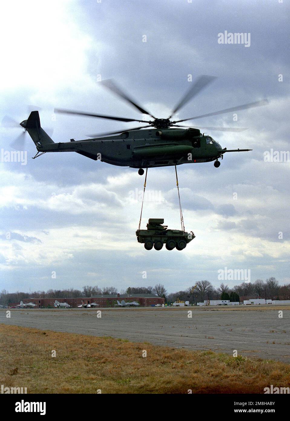 Ein Marine CH-53E Super-Hallion-Hubschrauber trägt extern ein leichtes gepanzertes LAV-25-Fahrzeug während des Fluges gegen einen bedeckten Himmel. Basis: Marinestützpunkt, Quantico Bundesstaat: Virginia (VA) Land: Vereinigte Staaten von Amerika (USA) Stockfoto