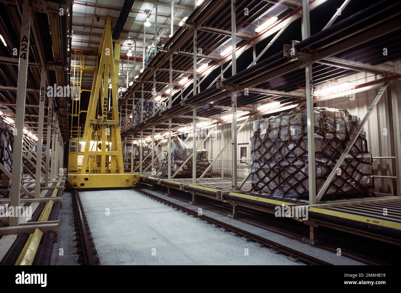Das Elevating Transfer Vehicle (ETV), eine Komponente des neuen mechanisierten Materialtransportsystems (MMHS), bewegt sich zwischen Regalen am 316. Aerial Port Squadron Dock. Das ETV wird zum Bergen und Transportieren von Paletten zu und von bestimmten Lagerbehältern verwendet, bevor sie an Bord wartender Flugzeuge verladen werden. Basis: Yokota Air Base Country: Japan (JPN) Stockfoto