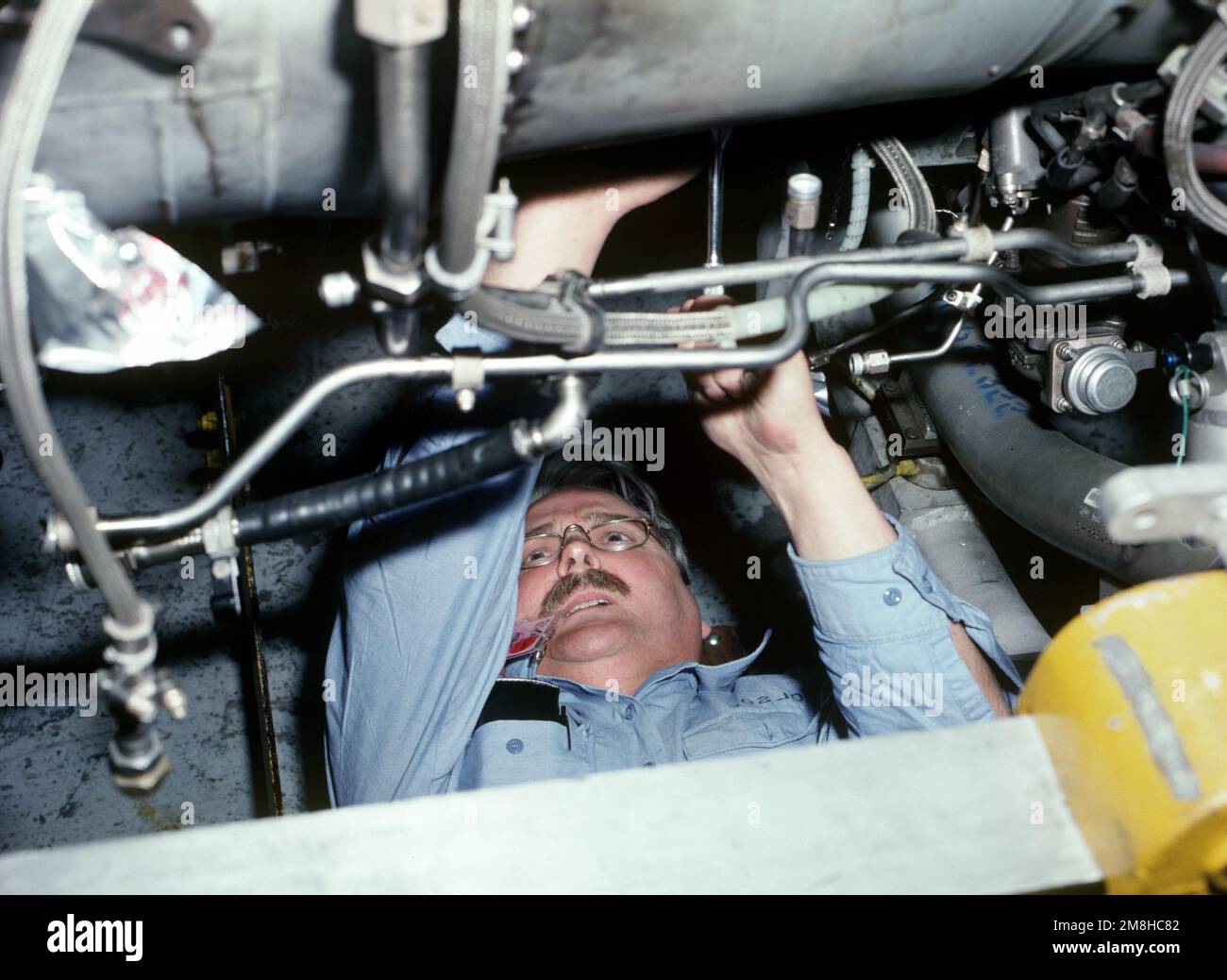 Aviation Machinist's Mate 1. Klasse Mike Olson, dem Naval Air Reserve Center in Minneapolis, Minnesota, zugewiesen, zieht die Schrauben der Kastenleitung an einem Flugzeugmotor fest. Olson ist auf der Flugstation für eine zweiwöchige aktive Trainingsperiode. Basis: Marineflugstation, Alameda Bundesstaat: Kalifornien (CA) Land: Vereinigte Staaten von Amerika (USA) Stockfoto