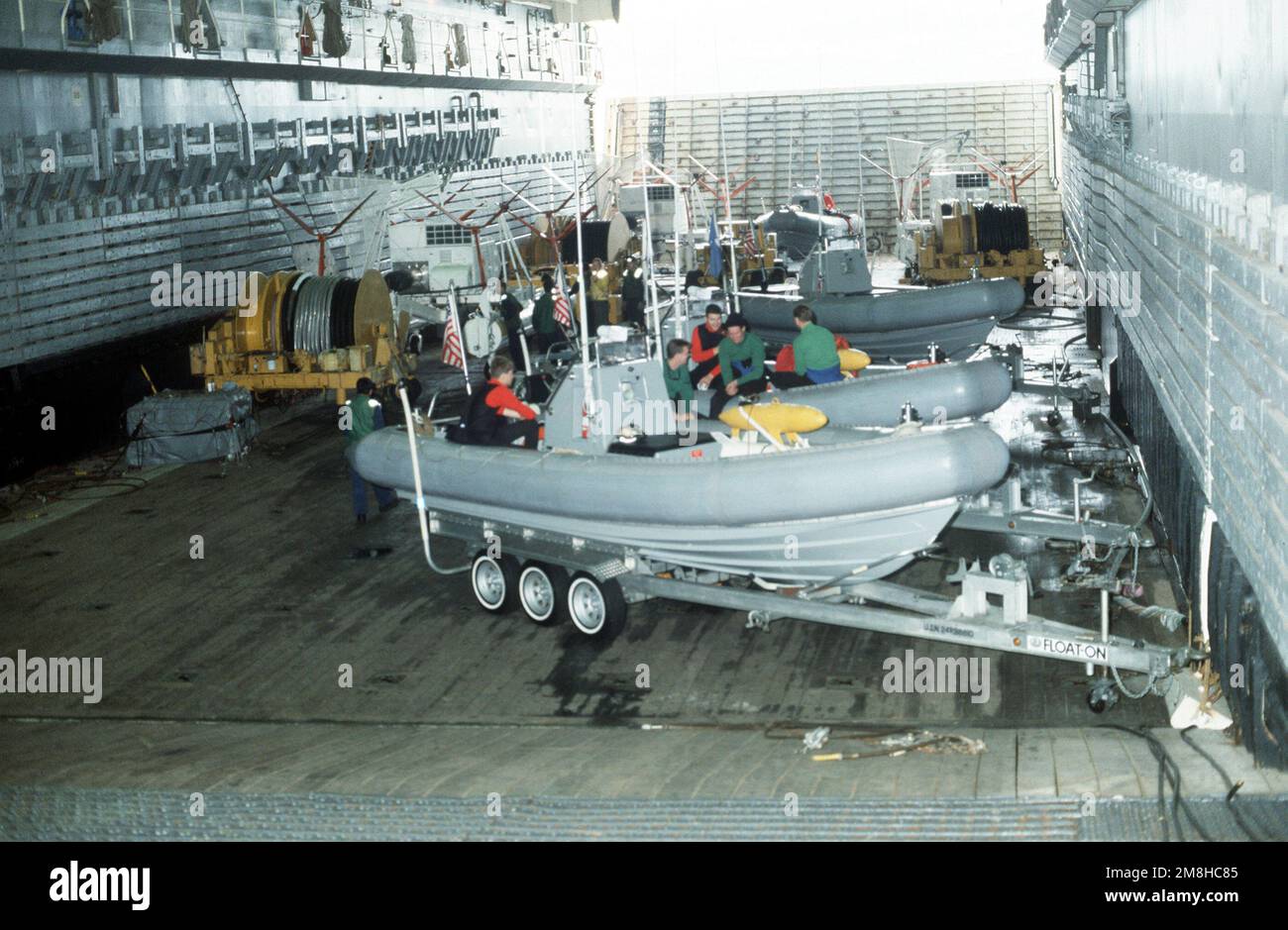 Mitglieder der Helicopter Mine Gegenmaßnahmen Staffel 15 (HM-15) entspannen sich, während sie in starren Schlauchbooten sitzen, die auf dem Brunnendeck der Amphibienladerampe USS DULUTH (LPD-6) gesichert sind. HM-15 nutzt die DULUTH als Basis für Operationen während der gemeinsamen US-kanadischen Flottenübung MARCOT '93. Betreff Operation/Serie: MARCOT '93 Land: Straße von Juan De Fuca Stockfoto