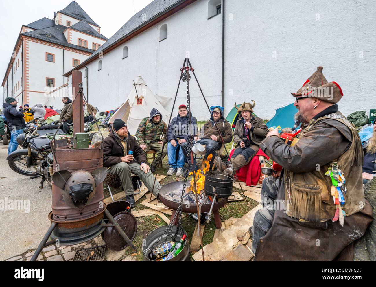 Augustusburg, Deutschland. 14. Januar 2023. Teilnehmer des Wintertreffens von Motorradfahrern im Jahr 50. haben sich im Schloss Augustusburg um eine Feuerschale versammelt. Nach der Annullierung der letzten zwei Jahre aufgrund der Pandemie sind etwa 1300 Biker aus Deutschland und dem Ausland für die Jubiläumsausgabe angekommen. Das erste offizielle Wintertreffen fand 1971 unter schneebedeckten Bedingungen statt. Kredit: Kristin Schmidt/dpa/Alamy Live News Stockfoto
