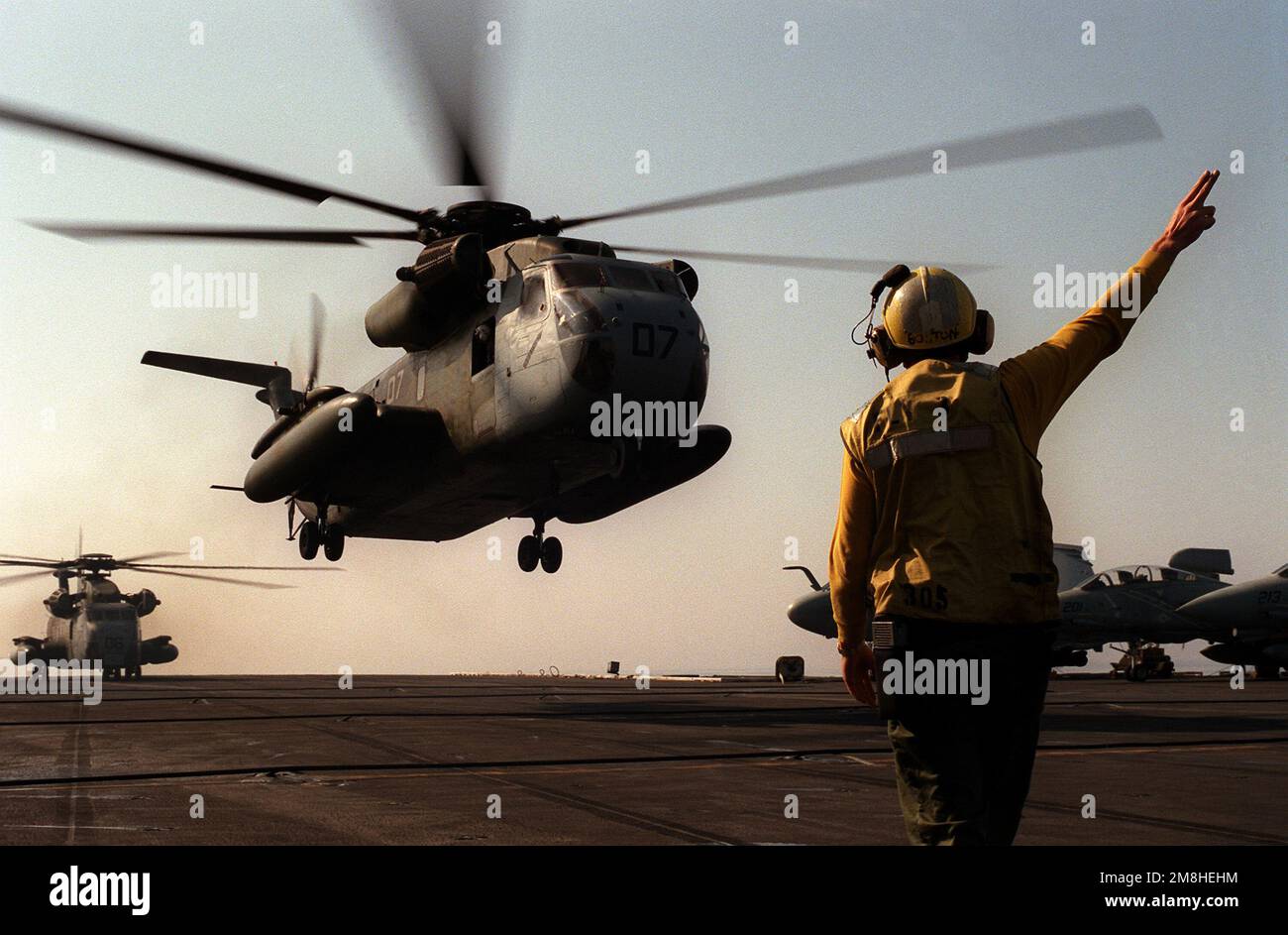 Ein Flugzeugführer hält das Startsignal, wenn ein Marine Heavy Helicopter Squadron 362 (HHH-362) CH-53D Sea Hallion Helicopter vom nuklearbetriebenen Flugzeugträger USS THEODORE ROOSEVELT (CVN-71) startet. Die ROOSEVELT operiert in der Adria im Rahmen von Operation Deny Flight. Betreff Betrieb/Serie: DENY-FLUG Land: Adriatisches Meer Stockfoto