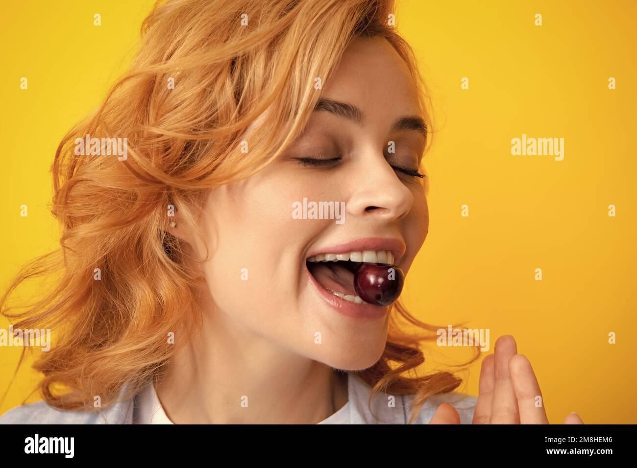 Womans genießen frische süße Kirsche. Weiblicher Mund, der süße Kirsche isst. Closeup weibliche Mund schmeckende süße Kirsche. Stockfoto