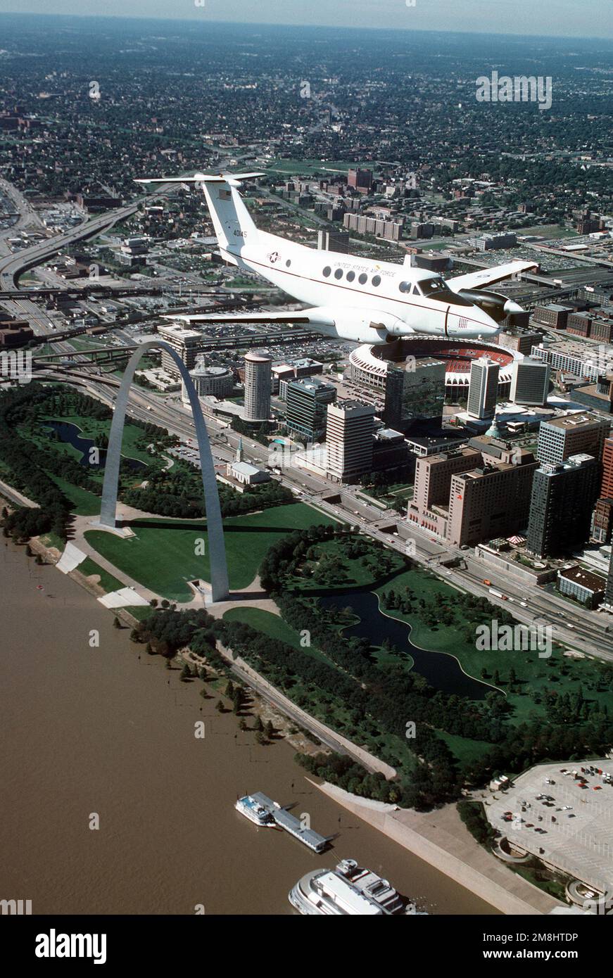 Eine dreiviertel-Vorderansicht eines in Beech gebauten C-12F-Flugzeugs während eines Fluges über den berühmten St. Louis Arch, am Ufer des Mississippi River und im Busch-Stadion. Die C-12F ist dem 375. Airlift Wing, Air Mobility Command, zugewiesen. Stützpunkt: Luftwaffenstützpunkt Scott Bundesstaat: Illinois (IL) Land: Vereinigte Staaten von Amerika (USA) Stockfoto