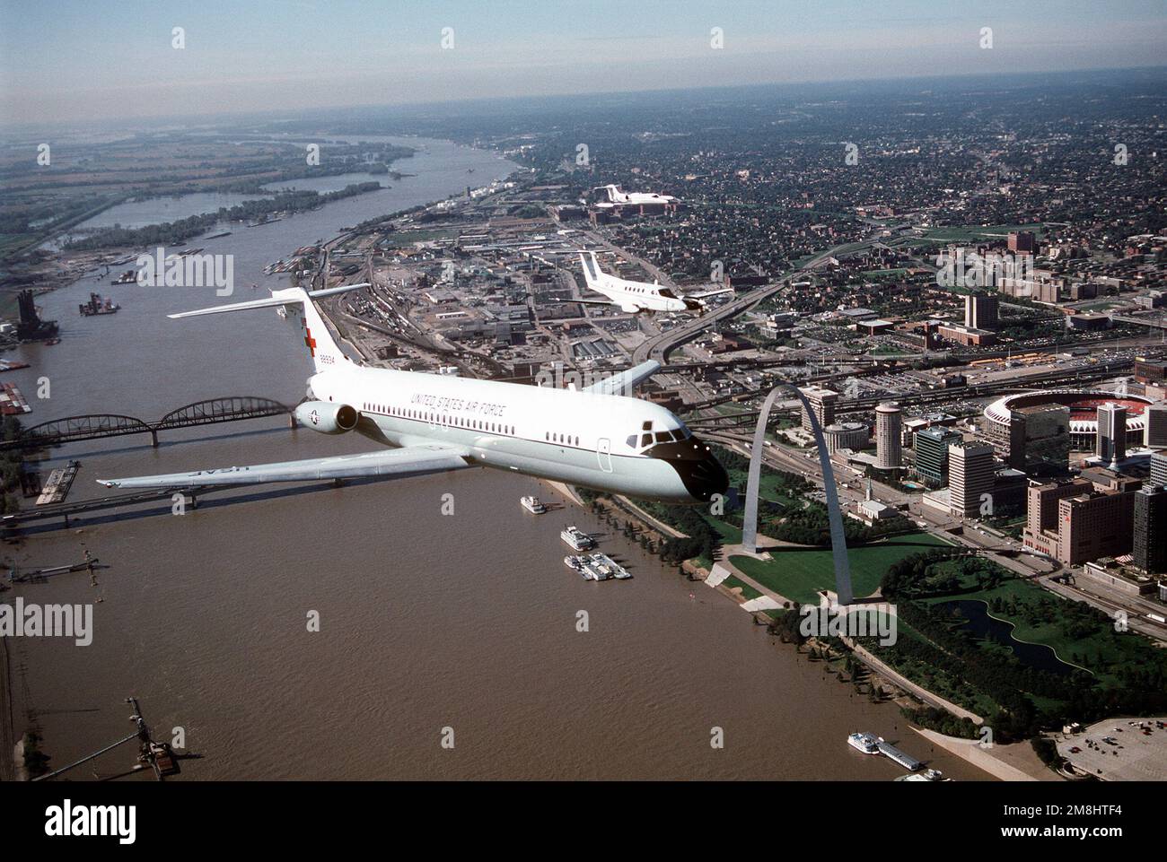 Eine Luft-zu-Luft-Vorderansicht eines von McDonnell Douglas gebauten C-9A Nightingale Flugzeugs, das eine Formation mit einem Beech-Flugzeug, gebaut C-12F, und einem Lear Jet, gebaut C-21A, führt. Der Trainingsflug geht über die berühmte St. Louis Arch am Ufer des Mississippi. Alle Flugzeuge sind vom 375. Luftwaffenflügel, Luftwaffenkommando. Stützpunkt: Luftwaffenstützpunkt Scott Bundesstaat: Illinois (IL) Land: Vereinigte Staaten von Amerika (USA) Stockfoto