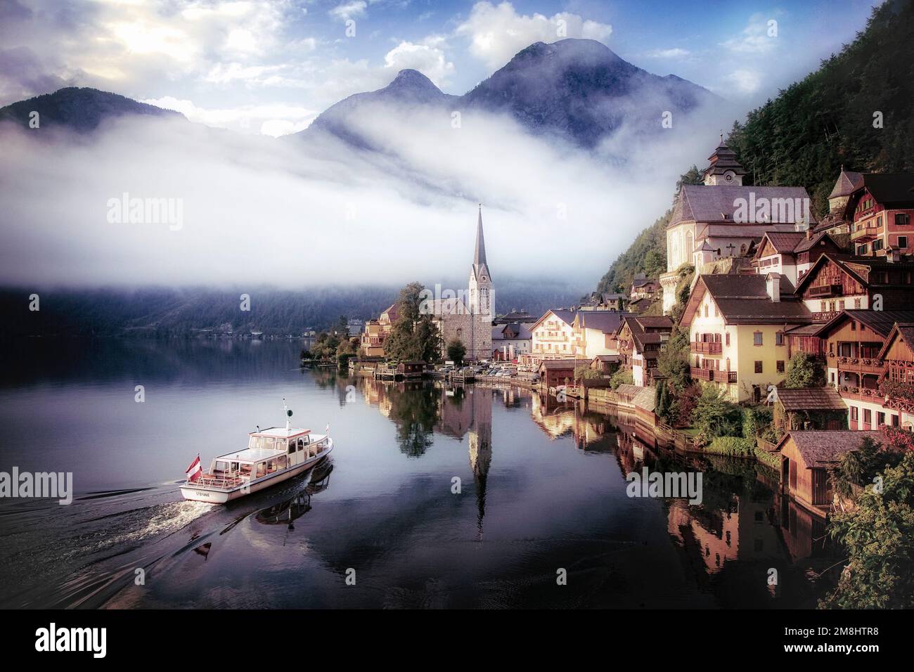 Ein Wassertaxi nähert sich dem kleinen historischen Dorf Hallstatt, Österreich. Stockfoto