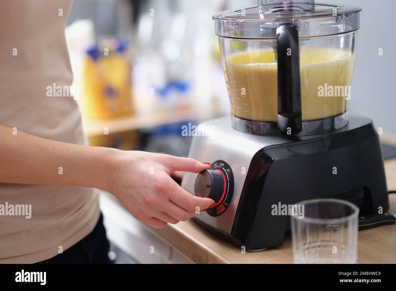 Die Frau bereitet Smoothie oder Teig im elektrischen Mixer zu Stockfoto