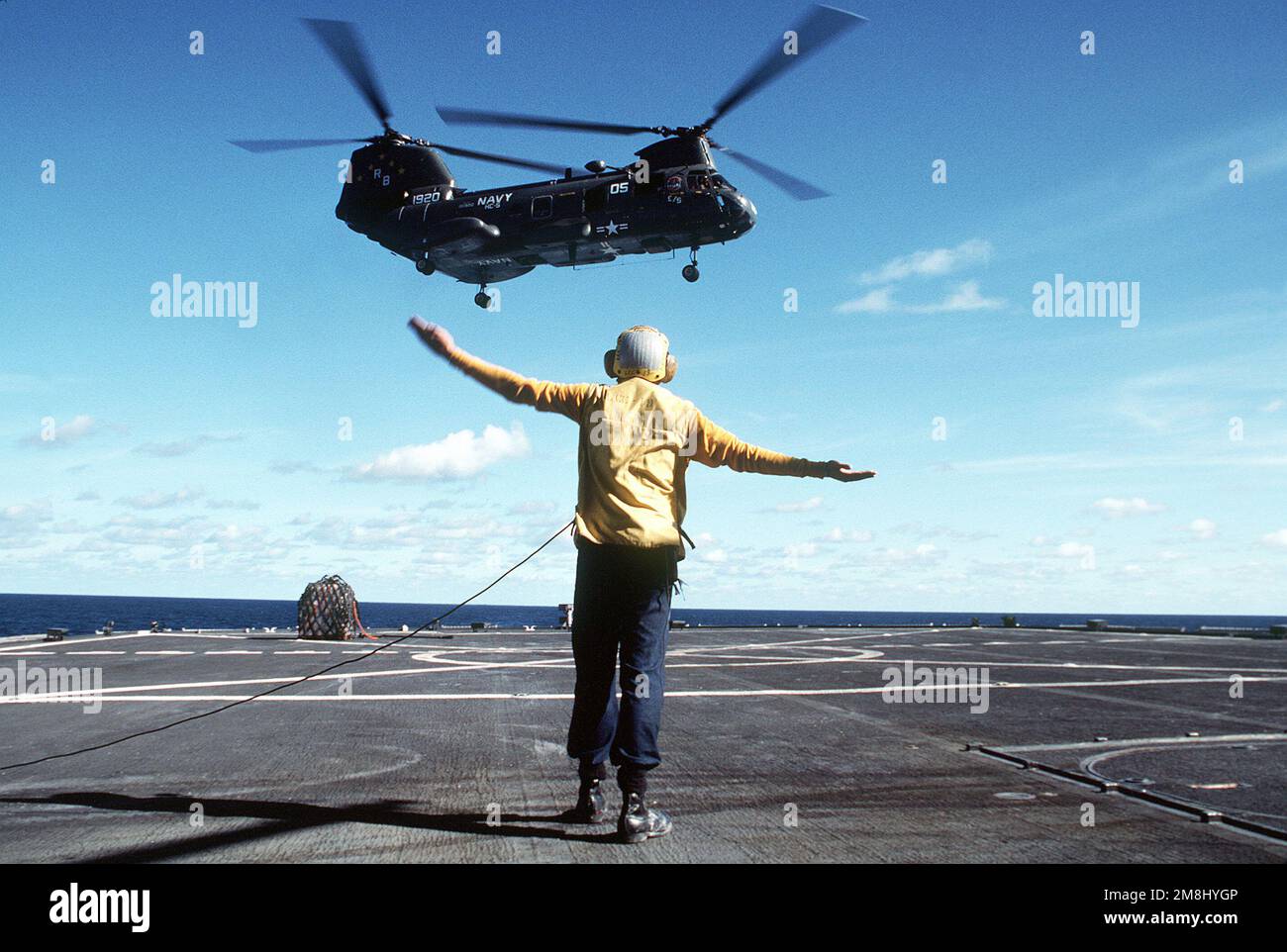 Landesignal Enlistedman (LSE) Boatswain Mate SEEMANN (BMSN) DeLuca signalisiert, dass ein Hubschrauberstützungstrupp fünf (C-5) CH-46 Sea Knight Helikopter von der USS MARS (AFS-1) gestartet werden soll, der mit dem USS BLUE RIDGE (LCC-19) einen vertikalen Auffüllvorgang durchführt, während zwei Schiffe unterwegs sind Nach Perth, Australien. Land: Pazifik (POC) Stockfoto
