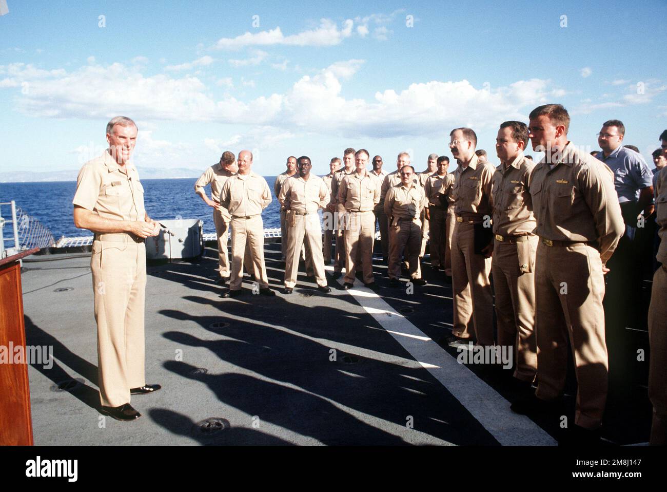 Konteradmiral Harold W. Gehman, Jr., Commander Cruiser Destroyer Group Acht und derzeit Commander Joint Task Force 120 sprechen vor der versammelten Besatzung des Raketenkreuzers USS YORKTOWN (CG-48) der Ticonderoga-Klasse, Captain Michael G. Mullen, während sich das Schiff Guantanamo Bay, Kuba, nähert. Die YORKTOWN macht eine Dienstreise vor der Küste von Haiti, als Teil der Operation Support Democracy. Betrifft Operation/Serie: UNTERSTÜTZUNG DER DEMOKRATIE Land: Karibik Stockfoto