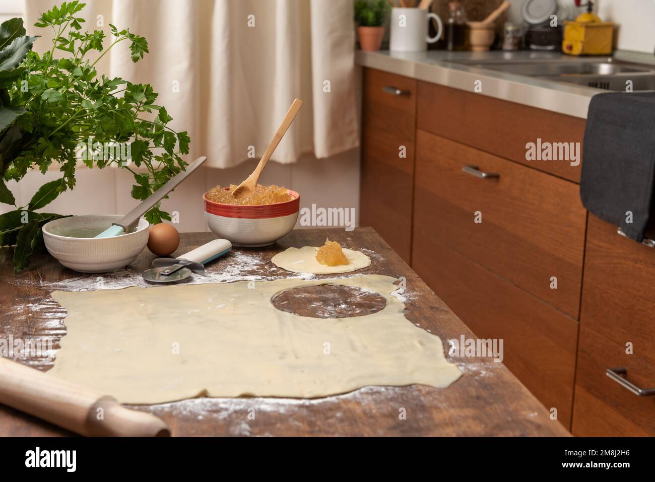 Heim Küchentisch mit einem Blätterteig, ausgeschnitten für panierte Süßigkeiten. Stockfoto