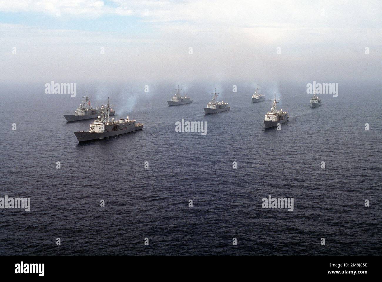 Destroyer Squadron One (DesRonOne), das in Formation vor der Küste von San Clemente Island dampft. Die Formation besteht aus sieben Schiffen der Klasse FFG der Naval Reserve Force. Von links nach rechts, hinten nach vorn; linke Reihe (hinten) USS SEITEN (FFG-14), (vorn) USS MAHLON S. TISDALE (FFG-27), mittlere Reihe (hinten) USS DUNCAN (FFG-10) (Mitte) USS COPELAND (FFG-25) (Hauptschiff) USS LEWIS B. ABZIEHER (FFG-23), rechte Reihe (FFG-12) (USS-FFG) (hinten) (USS-FFG) (USS-FFG) (USS-9). Land: Pazifik (POC) Stockfoto