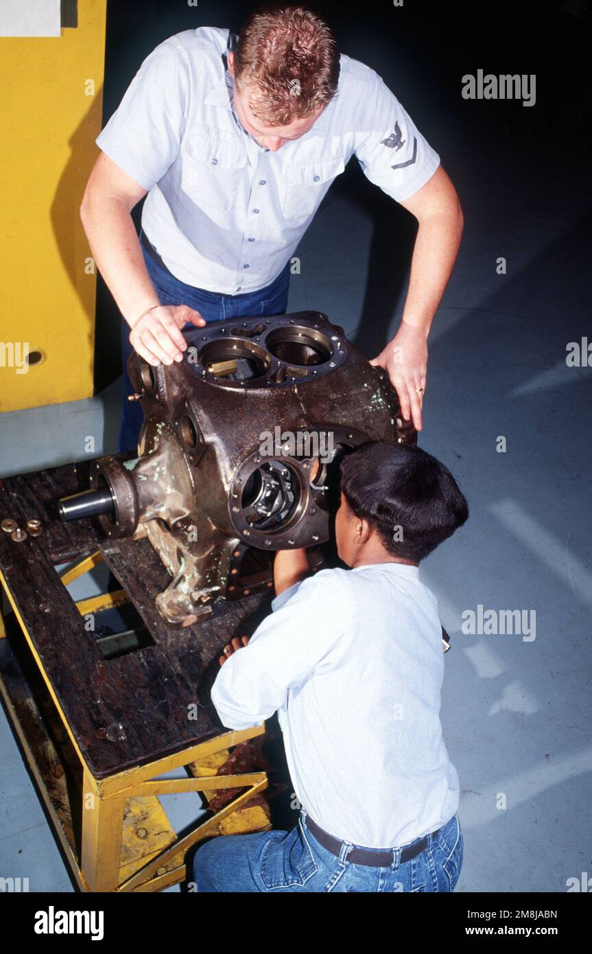 Machinist's Mate Third Class (MM3) James Robertson und Juanice Simmons installieren und richten den Zylinder in einem Kühlfach-Luftkompressor in der Werkstatt für Klimaanlagen und Kühlschränke bei Shore Intermediate Maintenance Activity, San Diego (SIMA) aus. Basis: San Diego Staat: Kalifornien (CA) Land: Vereinigte Staaten von Amerika (USA) Stockfoto