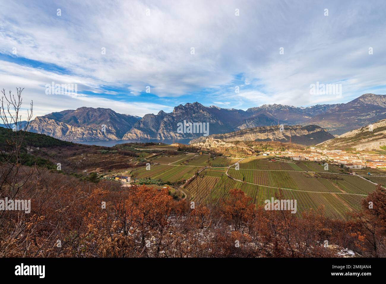 Blick aus der Vogelperspektive auf den Gardasee mit den Alpen und das kleine Dorf Nago-Torbole, Blick von den Bergen Monte Baldo, Trentino Alto Adige, Italien Stockfoto