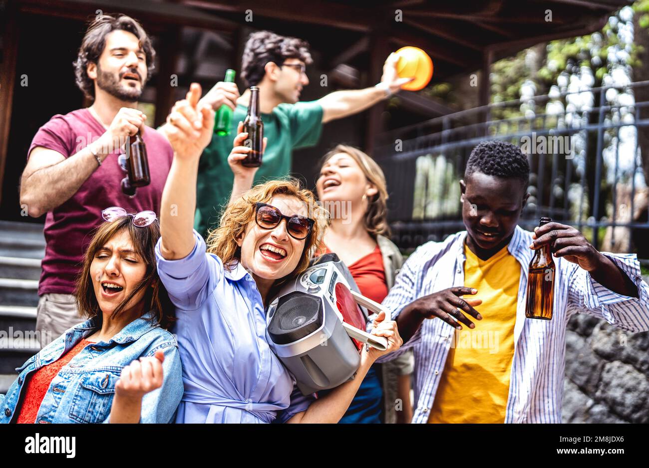 Multikulturelle Personengruppe, die Spaß im Freien hat und mit Boombox und Bierflasche jubelt - gemischte Altersfreunde genießen gemeinsam das Spring Break Party Festival Stockfoto
