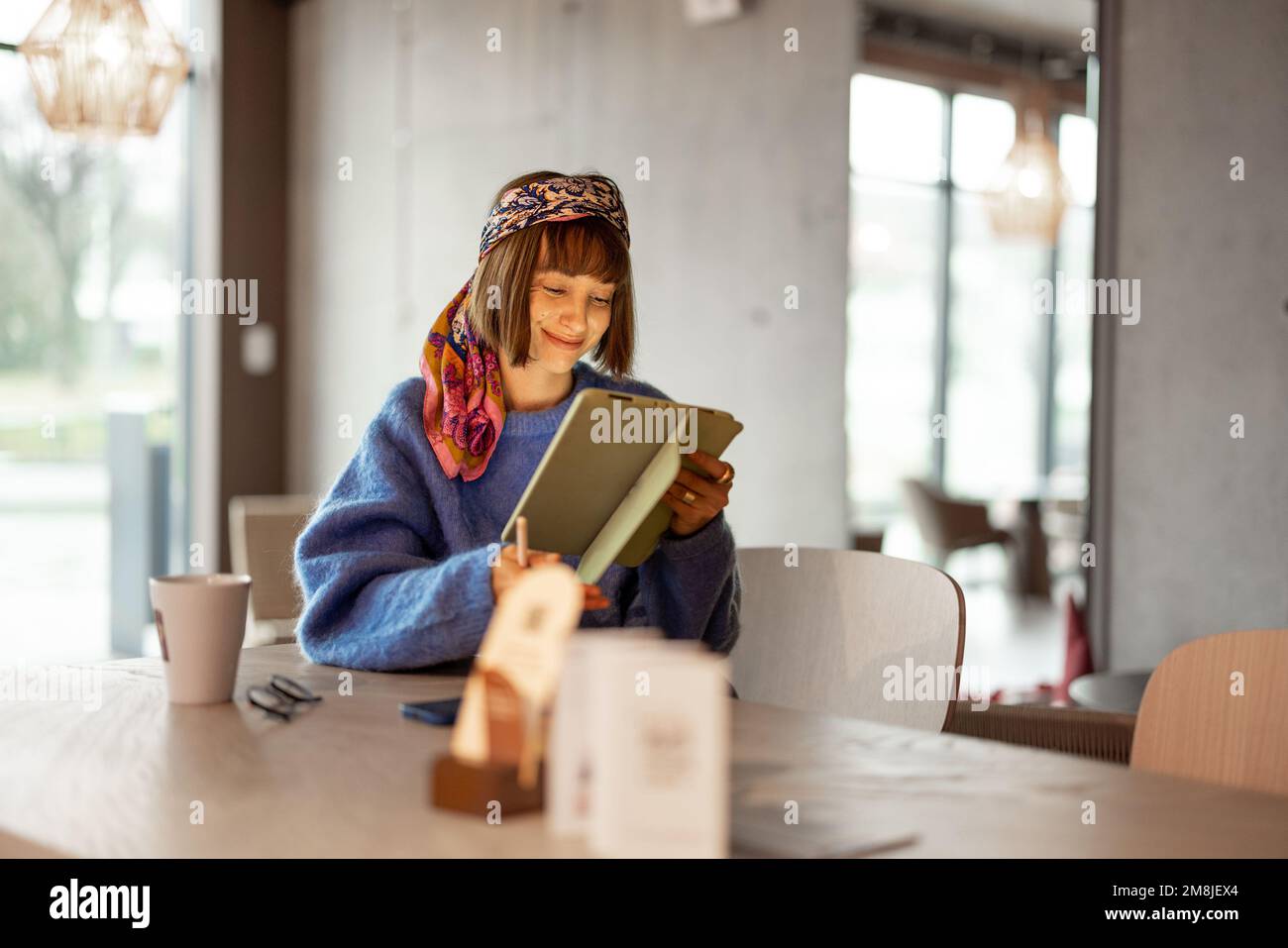 Frau arbeitet an Touchpad im Café Stockfoto