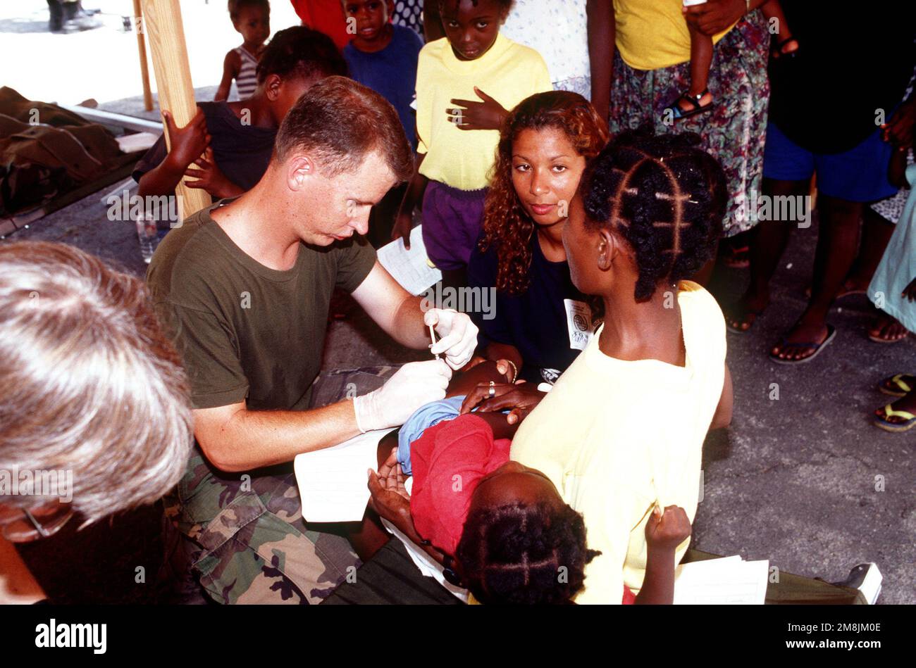 Hospital Corpsman Third Class (HM3) Jeff Mueller, 2. Medical Force Service Support Group (FSSG) Bataillon gibt haitianischen Kindern die erforderlichen Impfungen. Wenn sie jünger als 7 Jahre sind, erhalten sie eine DPT- und HIB-Impfung und müssen über 9 Monate alt sein, um eine MMR-Impfung zu erhalten. Für dieses Verfahren wurden zwei Zelte in Lager 4 eingerichtet. Betreff Betrieb/Serie: SEESIGNALBASIS: Guantanamo Bay Country: Kuba (CUB) Stockfoto