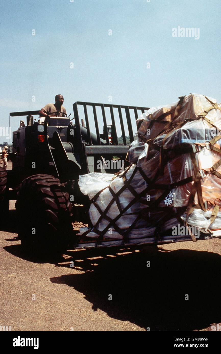 SENIOR AIRMAN Boo Brown, Gabelstaplerfahrer vom 62. Flugzeugschwadron McGuire AFB NJ, bringt Paletten zum Warten C-130 Hercules. Die Fracht wird später am selben Tag nach Kigali, Ruanda, geliefert. Betreff Operation/Serie: SUPPORT HOPE Base: Entebbe Land: Uganda (UGA) Stockfoto