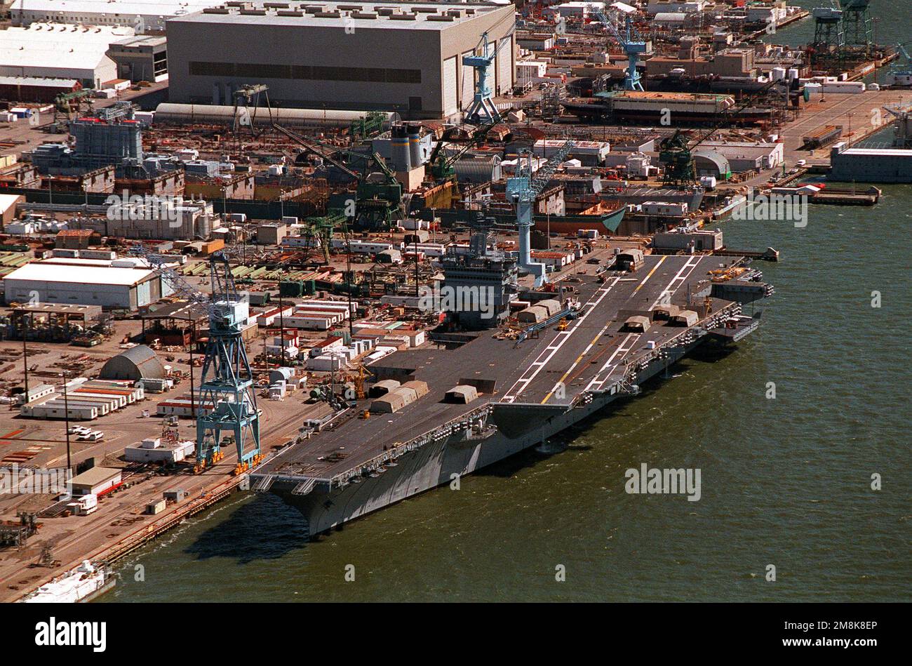 Eine Hafenbogenansicht des nukleargetriebenen Flugzeugträgers USS ENTERPRISE (CVN-65), der bei Newport News Shipbuilding und Drydock Corporation für eine Nachrüstung nach einer 44-monatigen Überholung, die die Wiederherstellung der rechten Reaktoren des Schiffes beinhaltete, festgemacht wurde. Basis: Newport News Bundesstaat: Virginia (VA) Land: Vereinigte Staaten von Amerika (USA) Stockfoto