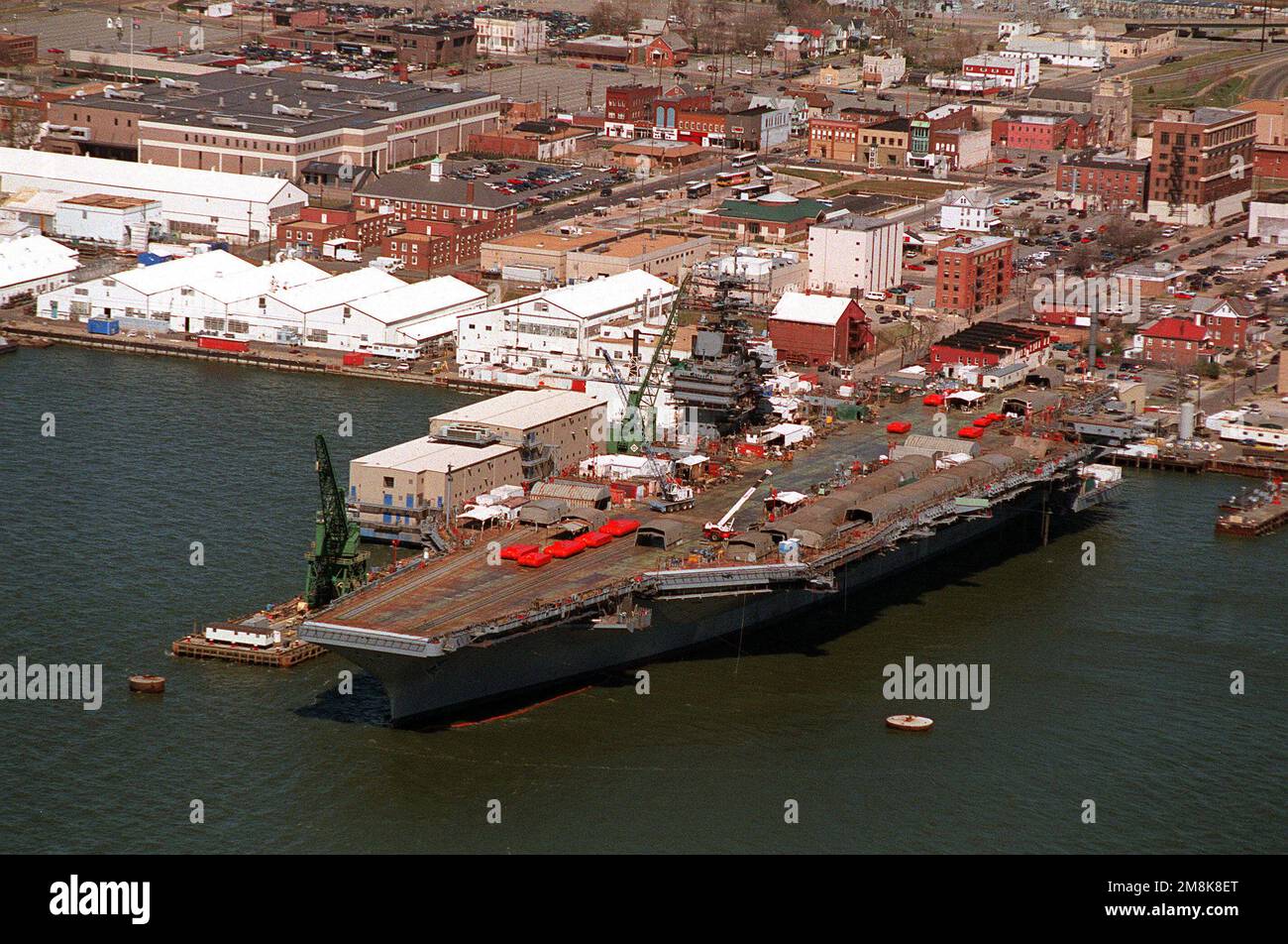 Ein Luftbogenblick auf den nuklearbetriebenen Flugzeugträger JOHN C. STENNIS (CVN-74) als Anlegestelle am Newport News Shipbuilding und der Drydock Corporation am James River. Die orangefarbenen Dollies auf dem Deck sind Katapult-Testbänke und werden aus den Katapulten getestet, um das Gewicht des Flugzeugs zu simulieren. Basis: Newport News Bundesstaat: Virginia (VA) Land: Vereinigte Staaten von Amerika (USA) Stockfoto