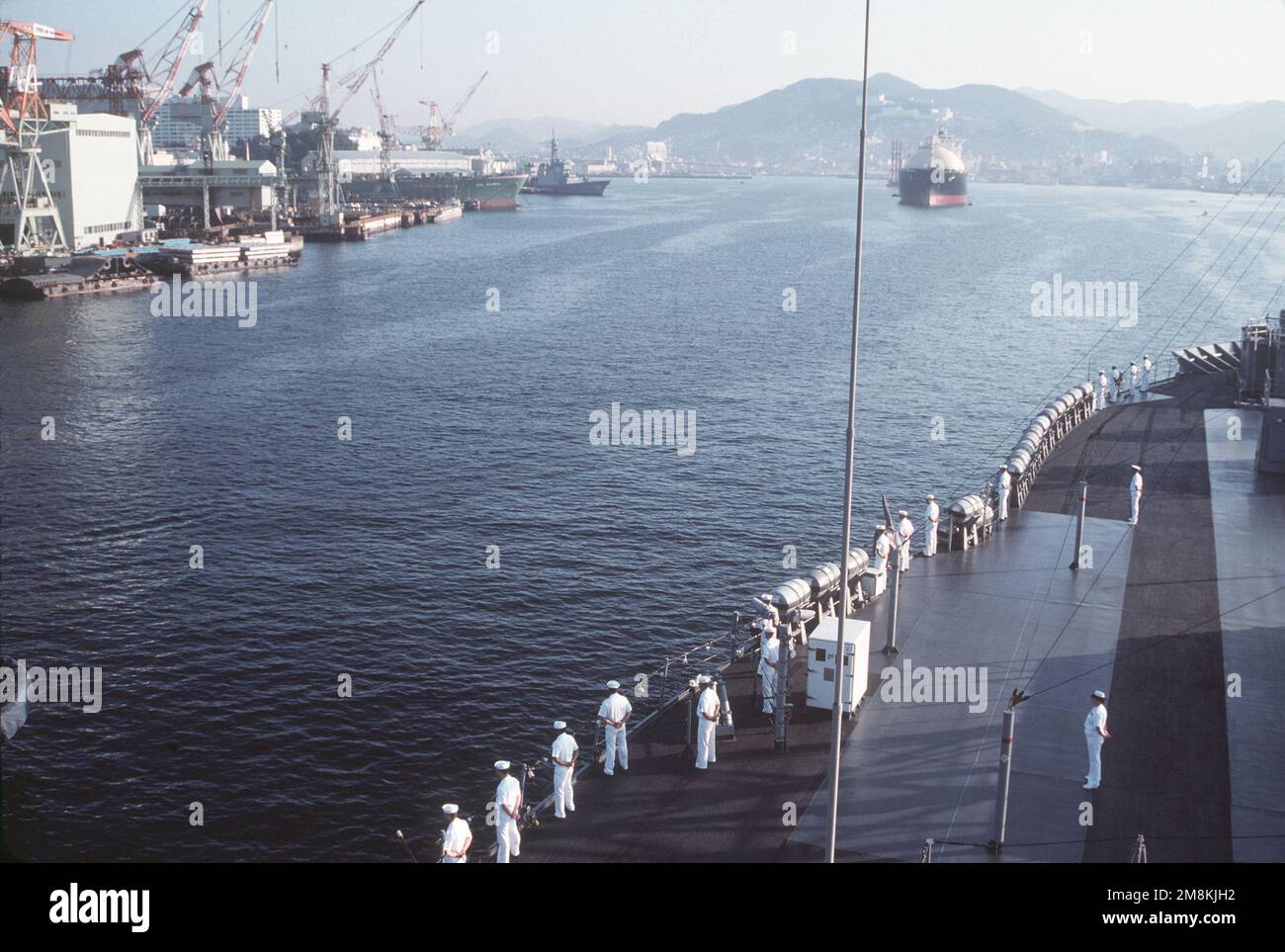 Ein Blick vom Bug des amphibischen Kommandoschiffs USS BLUE RIDGE (LCC-19), wenn das Schiff für einen Hafenbesuch ankommt. Links befindet sich die vierte Einheit des JMSDF KONGO-Klasse Aegis-Zerstörers DDG-176 am Ausstattungspier. Basis: Nagasaki Harbor Country: Japan (JPN) Stockfoto