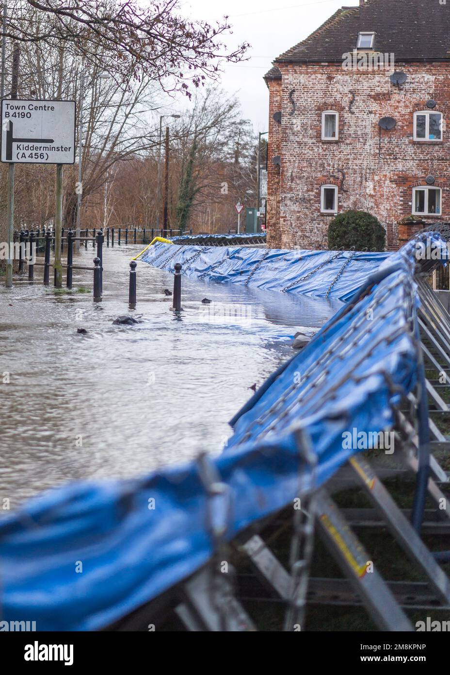 Bewdley, Großbritannien. 14. Januar 2023. Am Samstagabend setzen die Mitarbeiter der Umweltbehörde alles daran, die Sicherheit und den Schutz der Bewdleys Bewohner und Unternehmen zu gewährleisten. Da die Überschwemmung des Worcestershire River Severn gefährliche Pegel erreicht, weiß das Hochwassermanagement-Team der Umweltbehörde, dass es jetzt an der kritischen Zeit ist, die letzten Barrieren zu installieren. Das ist es - sie sind auf ihrer maximalen Höhe. Kredit: Lee Hudson/Alamy Live News Stockfoto