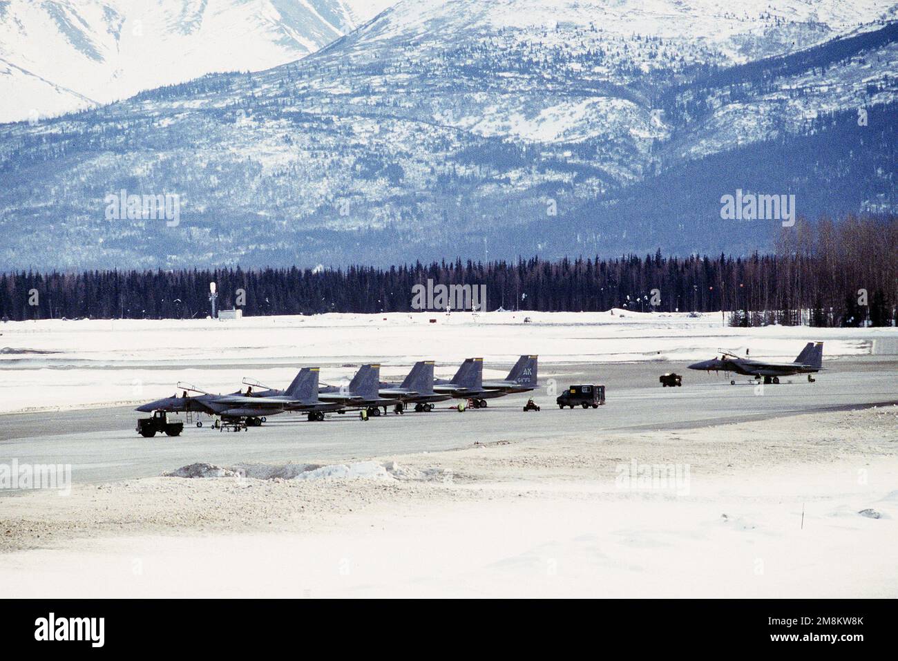 F-15 aus dem 54. Kampfgeschwader an der schneebedeckten Rampe. Im Hintergrund befinden sich die Chugach-Berge. Basis: Luftwaffenstützpunkt Elmendorf Bundesstaat: Alaska (AK) Land: Vereinigte Staaten von Amerika (USA) Stockfoto